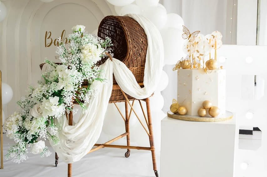 Baby shower styling with a cane bassinet and white blooms