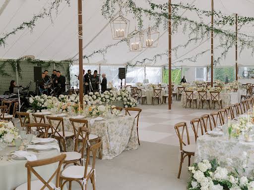 Marquee reception with long tables and greenery